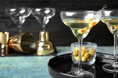 Photo of Glasses of Classic Dry Martini with olives on wooden table