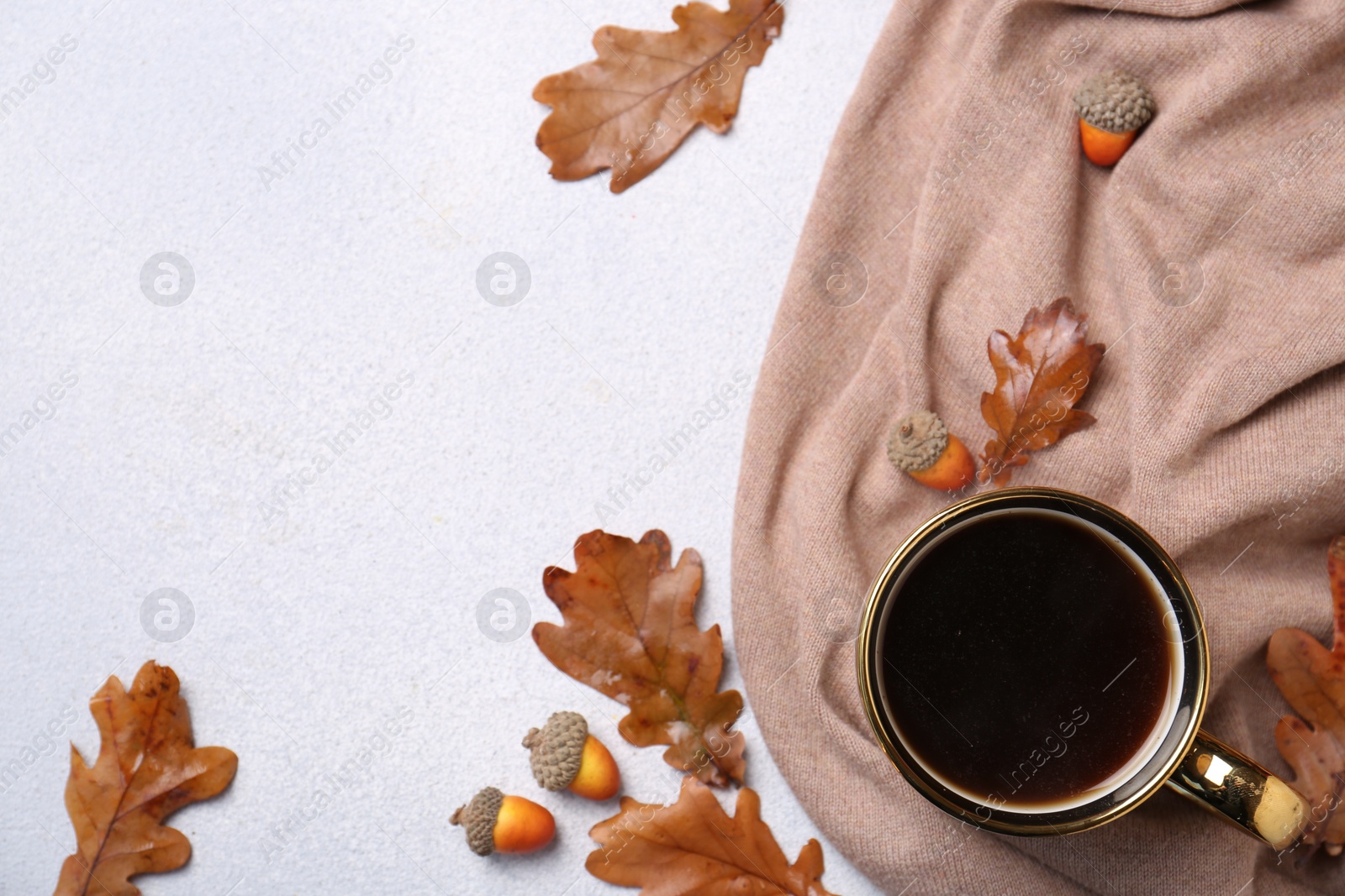 Photo of Flat lay composition with cup of hot drink and autumn leaves on light grey textured table. Space for text