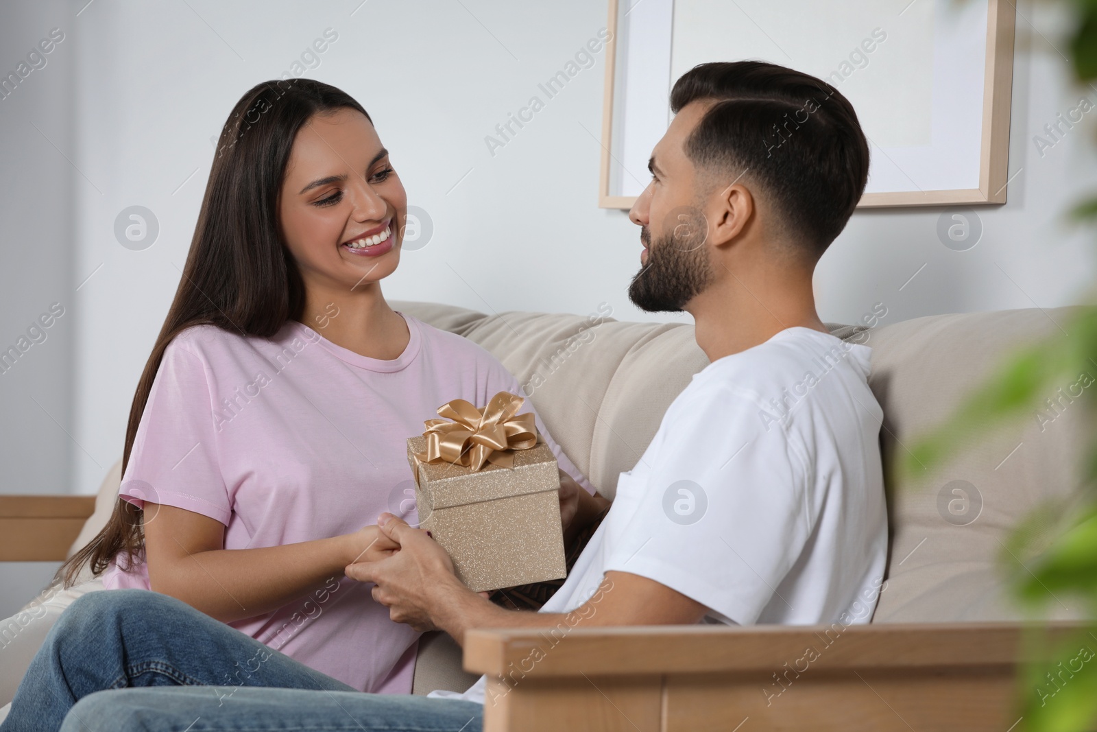 Photo of Lovely couple with beautiful gift at home