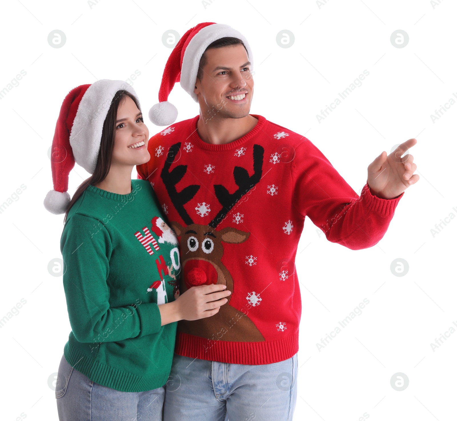 Photo of Beautiful happy couple in Santa hats and Christmas sweaters on white background