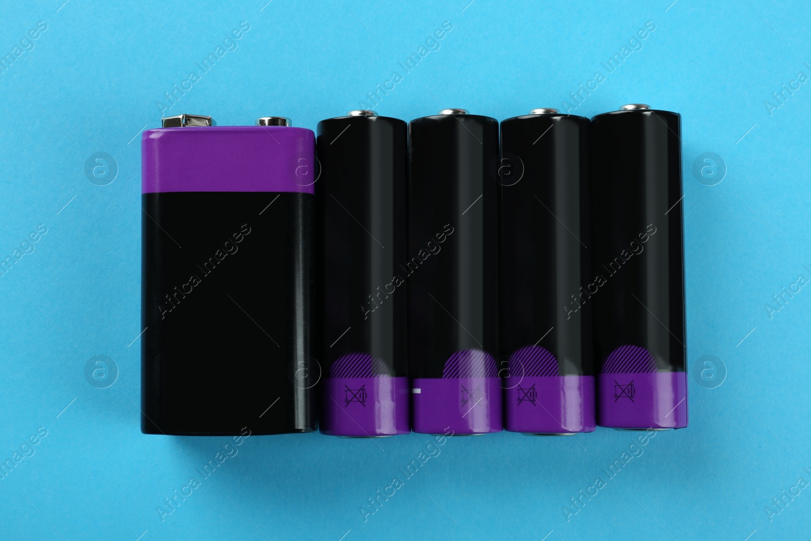 Image of Different batteries on turquoise background, flat lay