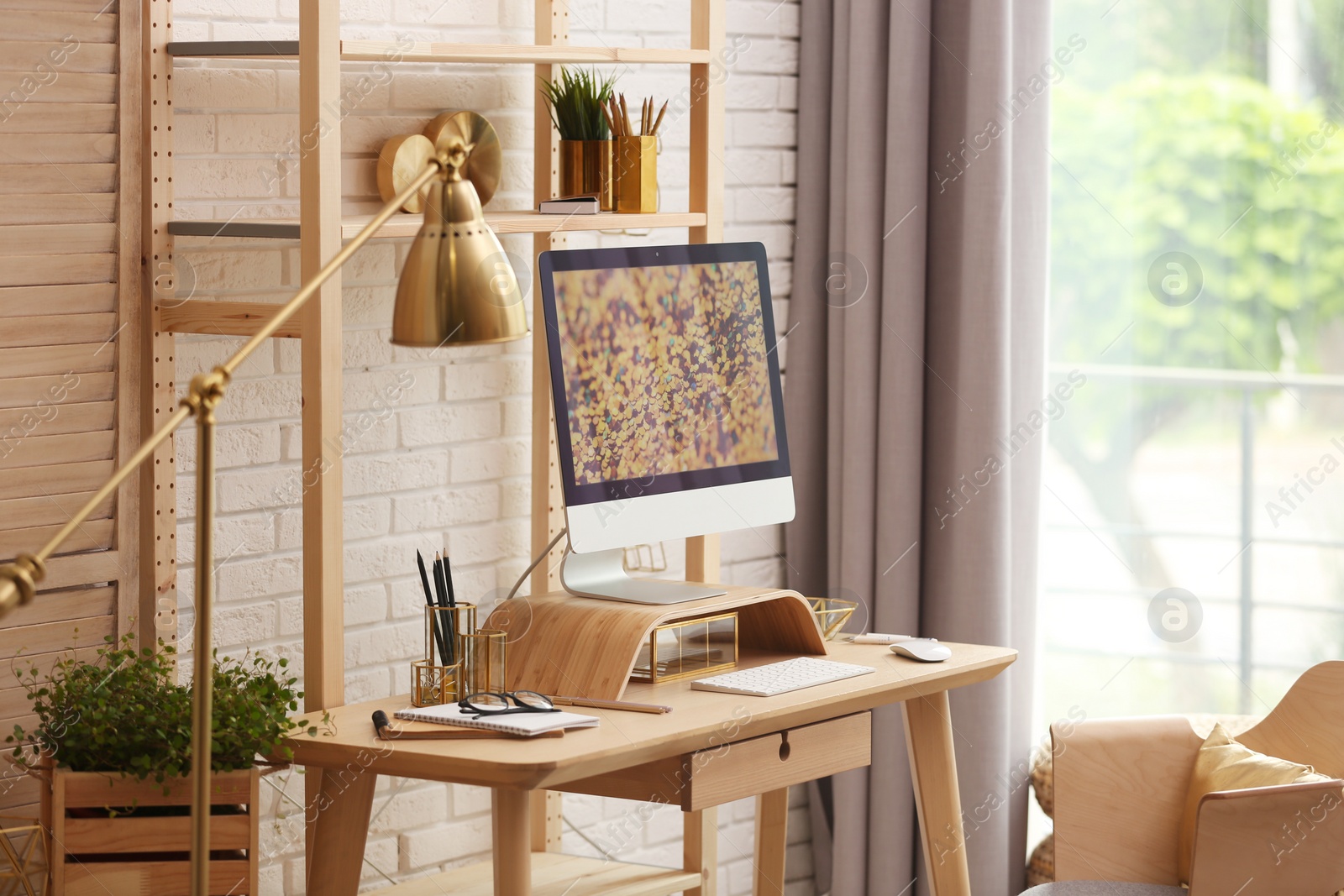 Photo of Stylish room interior with modern workplace at brick wall