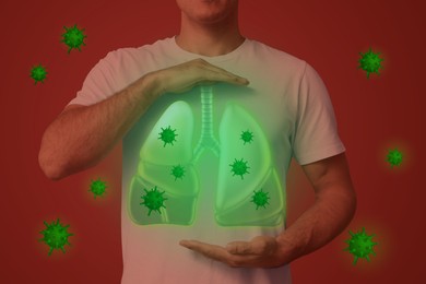 Man holding hands near chest with illustration of lungs and viruses that surrounding him on red background, closeup