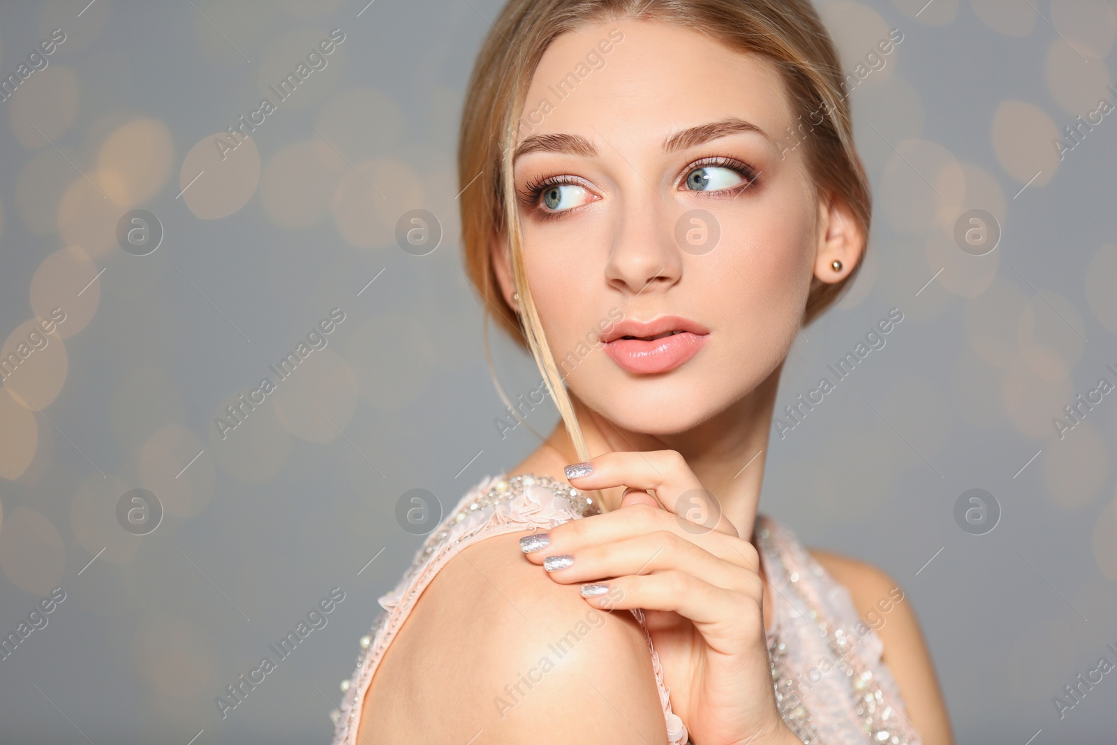 Photo of Beautiful young woman with shiny manicure on blurred background, space for text. Nail polish trends