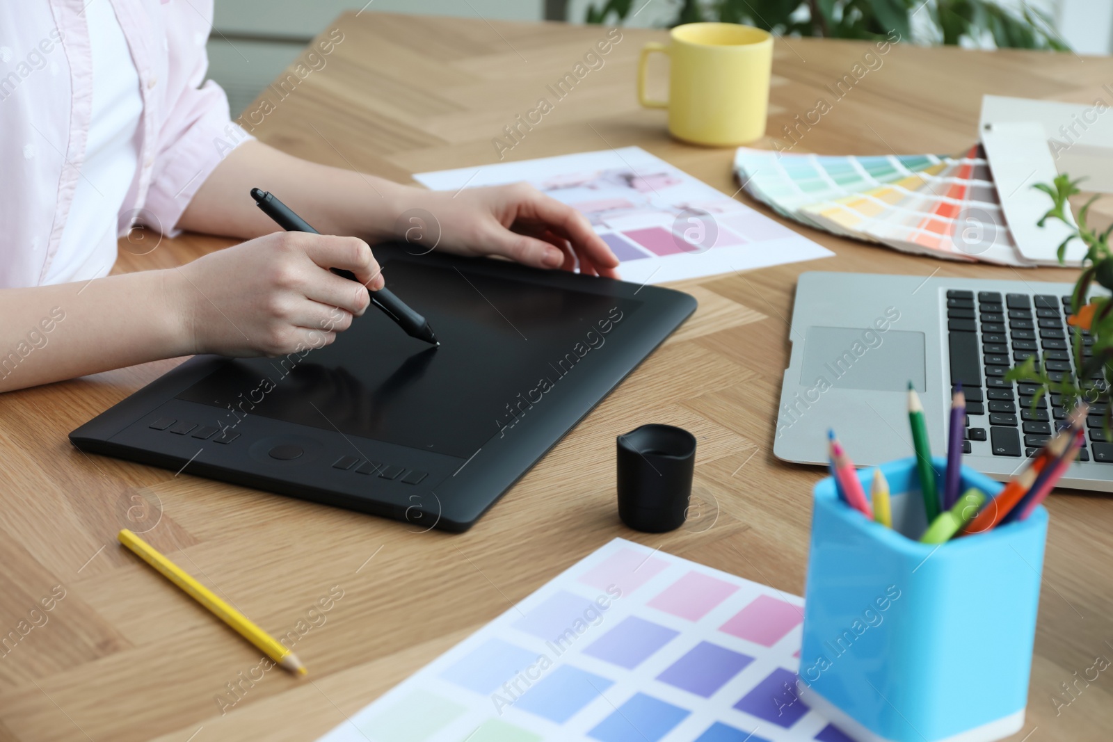 Photo of Professional designer with graphic tablet at wooden table, closeup