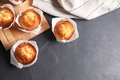 Photo of Tasty muffins on grey table, flat lay. Space for text