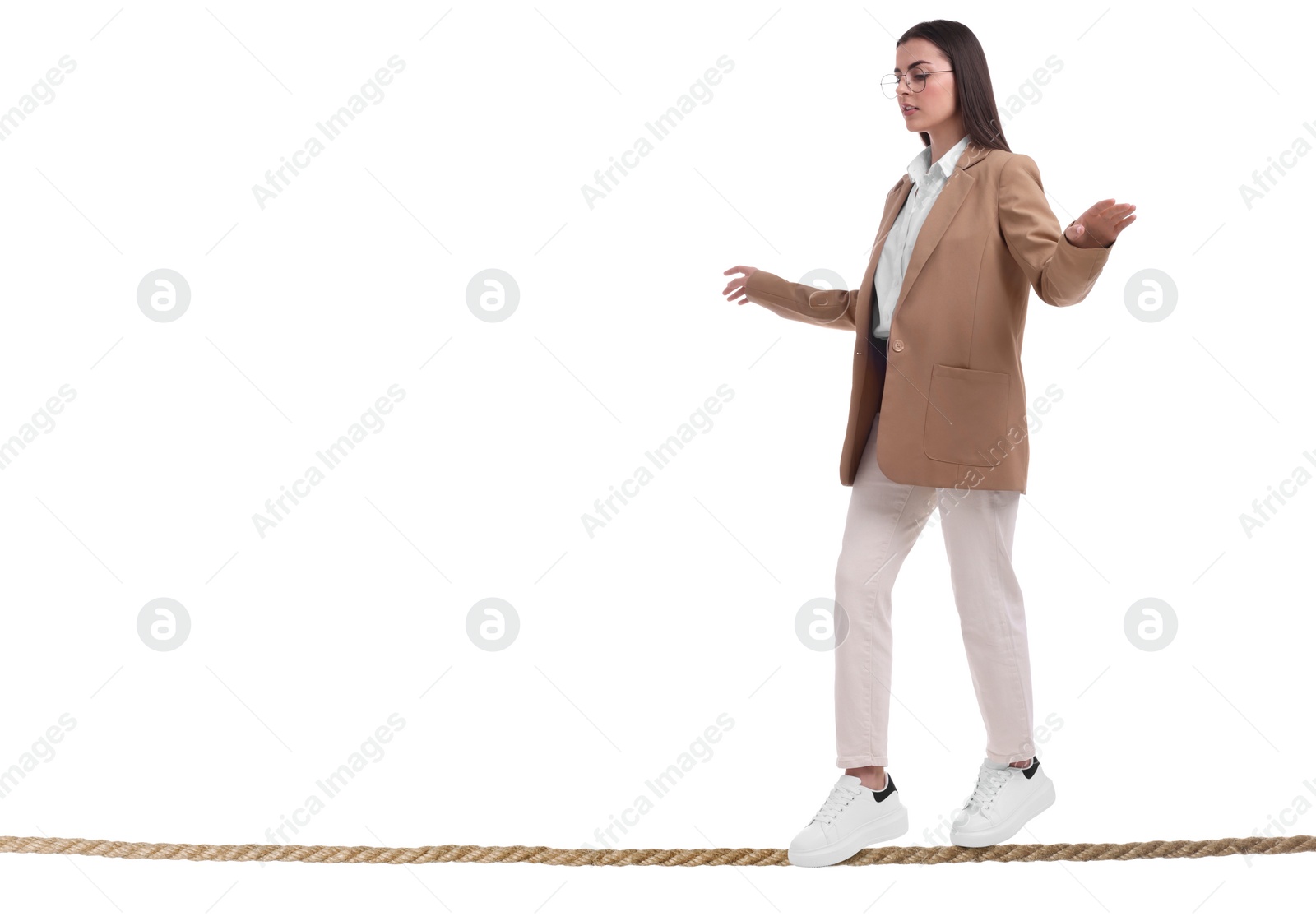 Image of Businesswoman walking rope against white background. Risk or balance concept