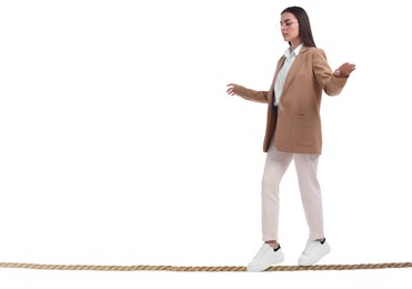 Businesswoman walking rope against white background. Risk or balance concept