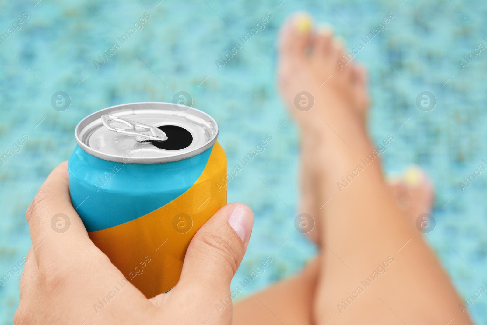 Photo of Woman holding aluminum can with beverage near swimming pool, closeup. Space for text