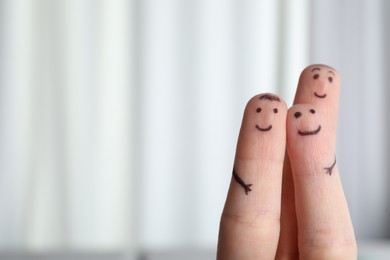 Photo of Three fingers with drawings of happy faces on blurred background, space for text