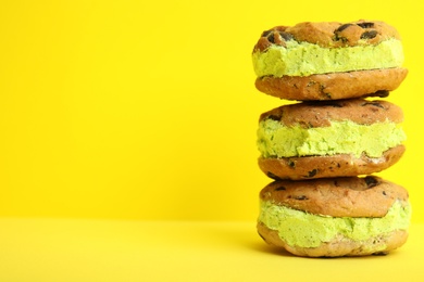 Photo of Sweet delicious ice cream cookie sandwiches on color background, space for text