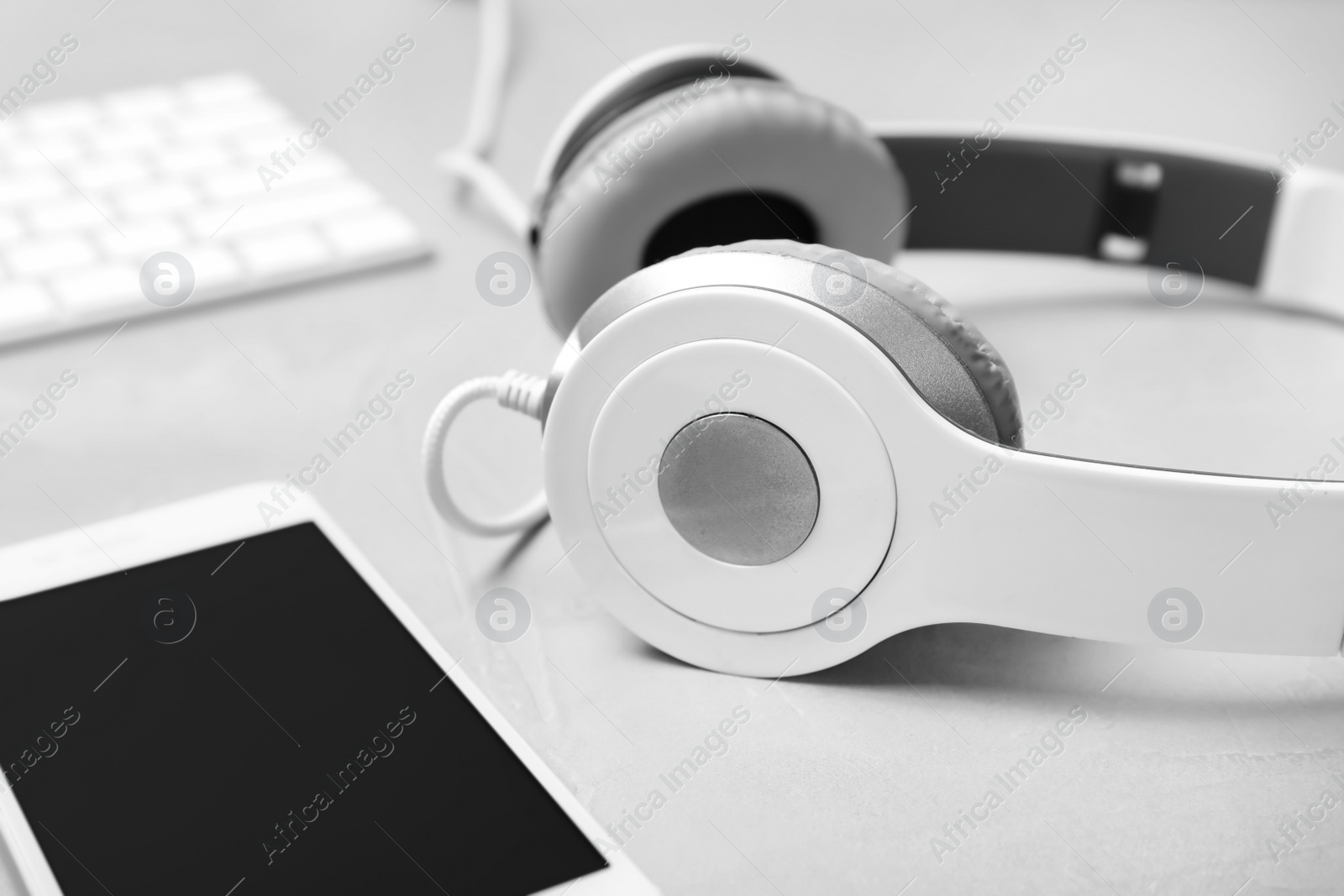 Photo of Headphones and smartphone on grey background, closeup