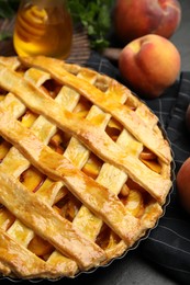 Photo of Delicious fresh peach pie on black table