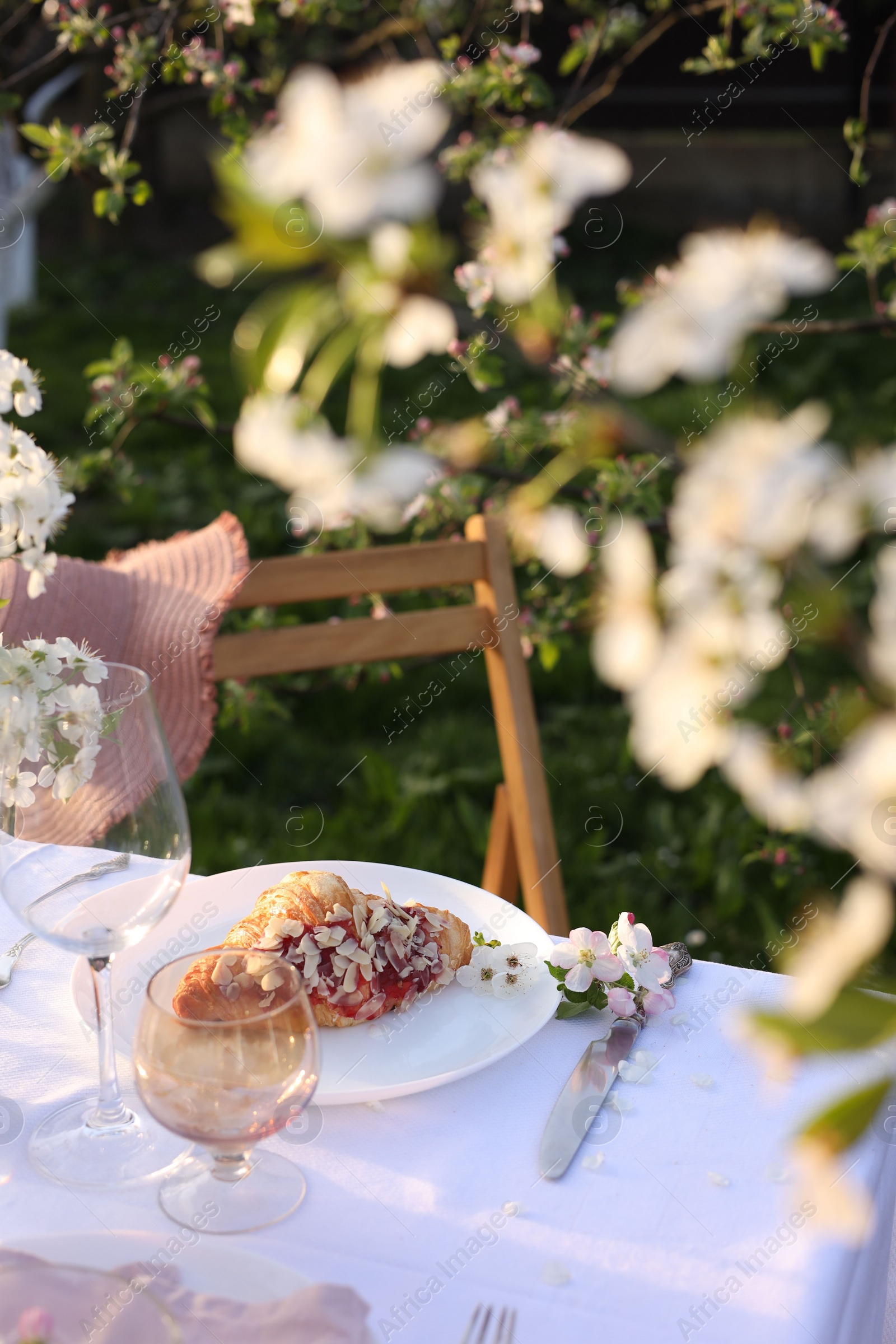 Photo of Stylish table setting with beautiful spring flowers in garden