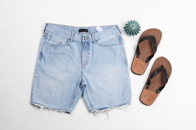 Photo of Flat lay composition with jean shorts and slippers on white background