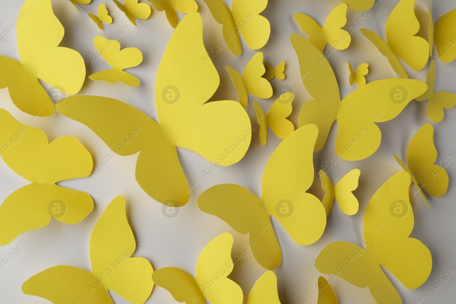 Photo of Yellow paper butterflies on light grey background, top view