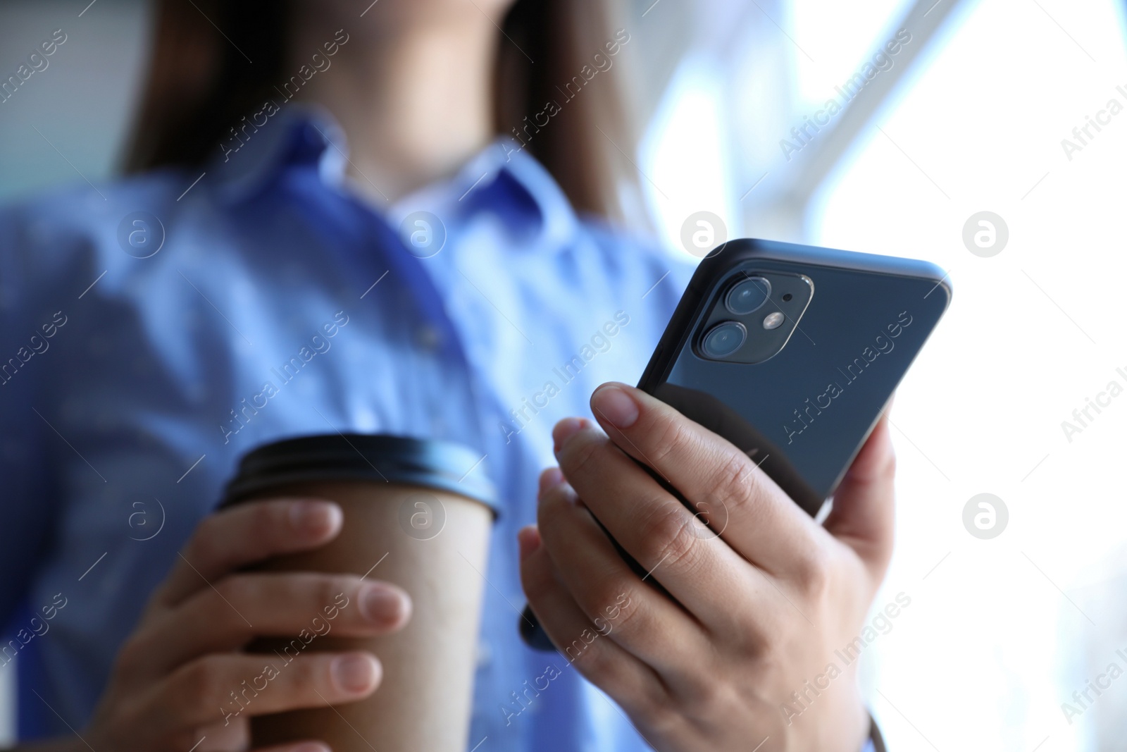 Photo of MYKOLAIV, UKRAINE - MARCH 16, 2020: Woman holding iPhone 11 Black indoors, closeup