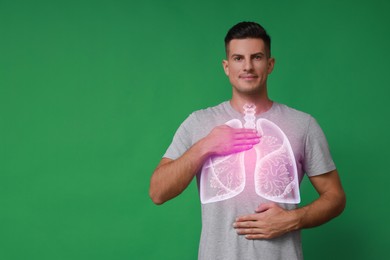 Image of Handsome man holding hands near chest with illustration of lungs on green background. Space for text