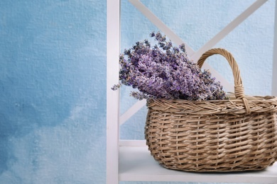 Photo of Wicker basket with lavender flowers on shelf