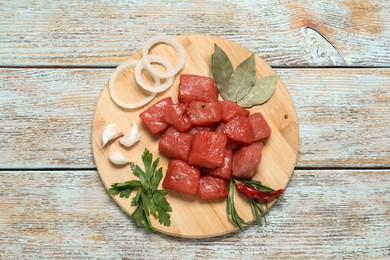 Photo of Raw beef meat and different ingredients for cooking delicious goulash on wooden table, top view