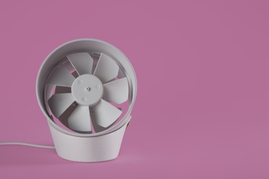 Photo of Modern electric fan on pink background. Space for text