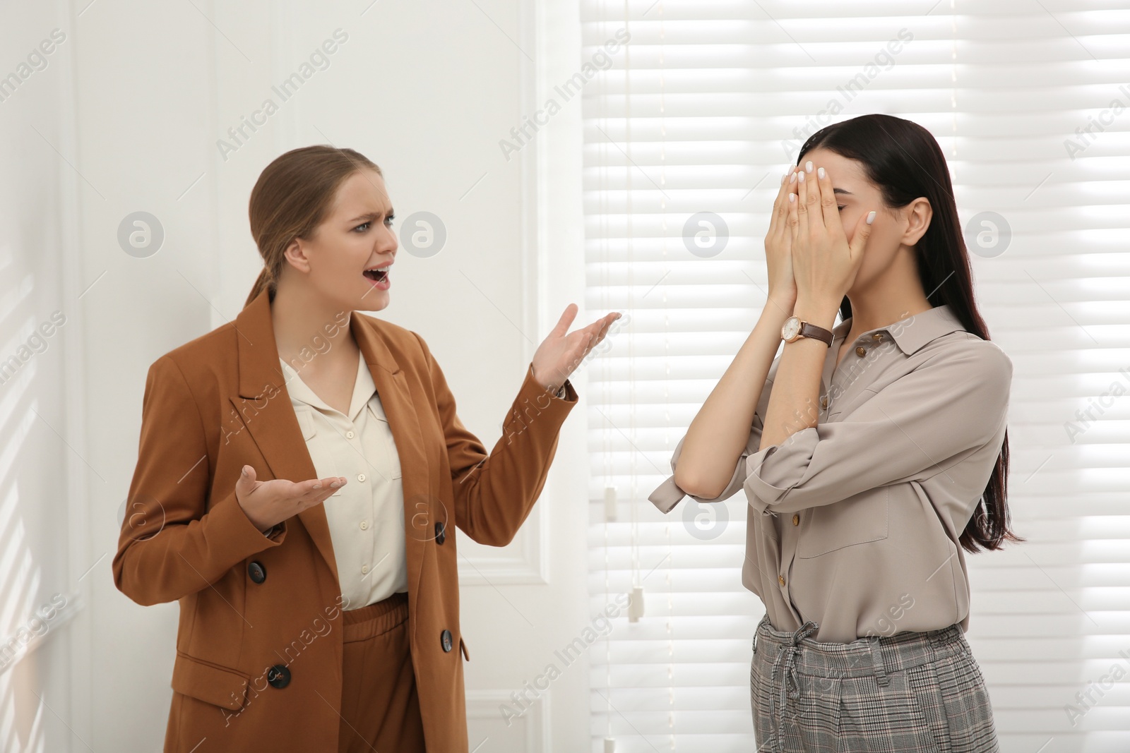 Photo of Boss screaming at employee in office. Toxic work environment