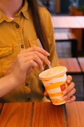 Photo of MYKOLAIV, UKRAINE - AUGUST 11, 2021: Woman with cold McDonald's drink in outdoor cafe, closeup