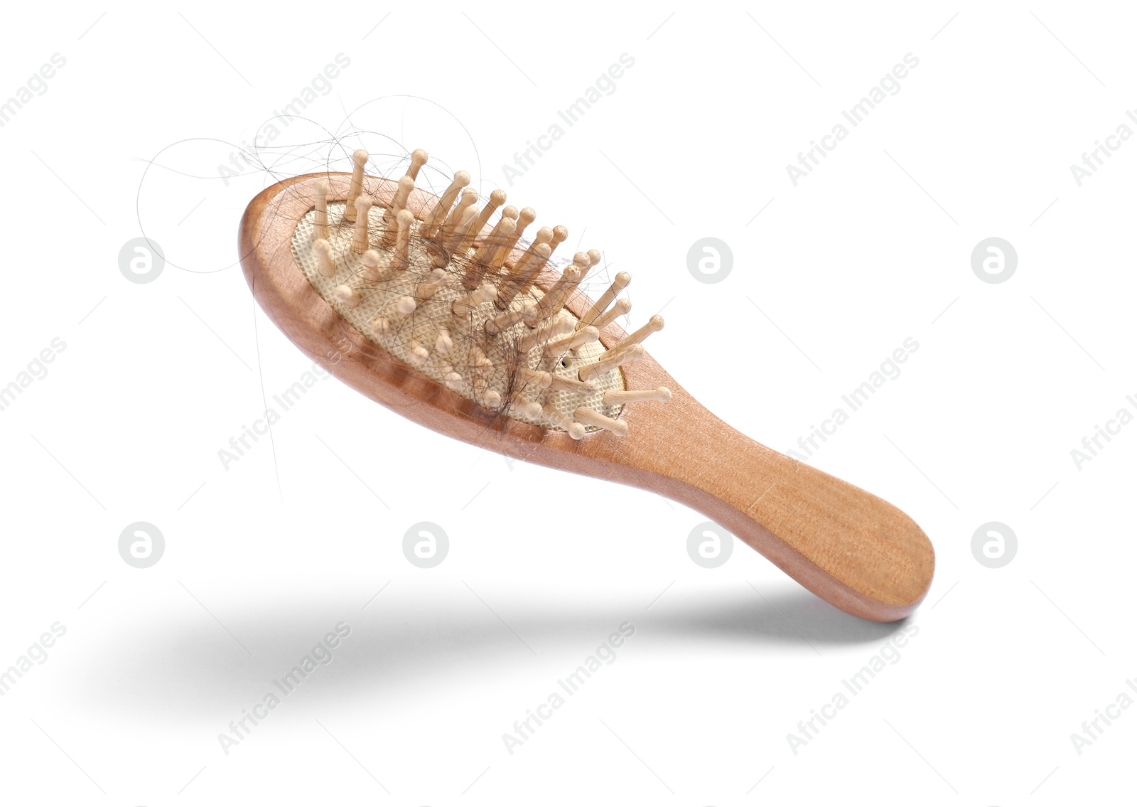 Photo of Brush with lost hair in air on white background