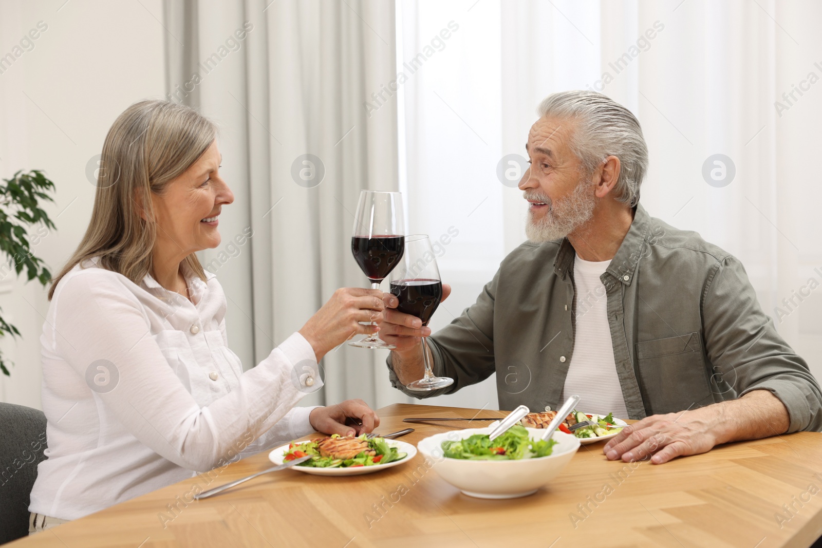 Photo of Happy senior couple having romantic dinner at home