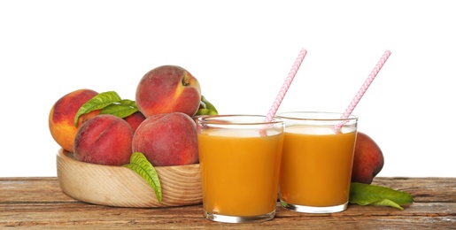 Natural freshly made peach juice on wooden table, white background