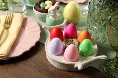 Photo of Festive Easter table setting with painted eggs, closeup