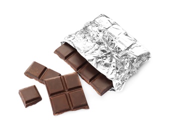 Photo of Delicious black chocolate bar in foil on white background