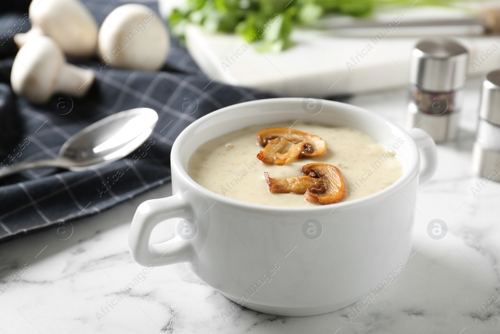 Photo of Delicious cream soup with mushrooms on white marble table