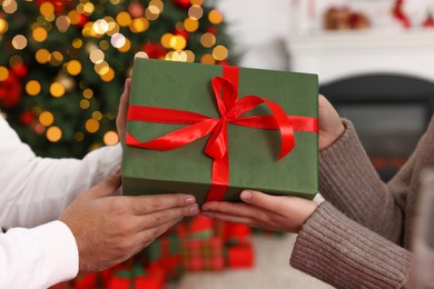 Photo of Woman receiving Christmas gift from her boyfriend at home, closeup