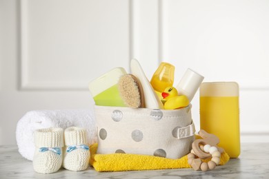 Photo of Baby booties and accessories on white marble table indoors