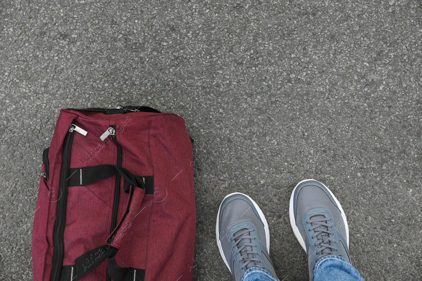 Photo of Man with bag standing on asphalt, top view. Space for text