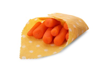 Photo of Many baby carrots in beeswax food wrap on white background