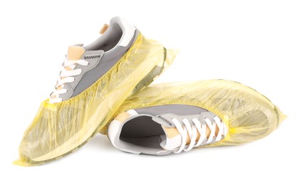 Men's sneakers in yellow shoe covers isolated on white