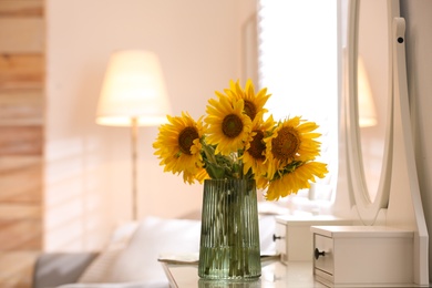 Photo of Beautiful bouquet of sunflowers in vase on white table indoors. Space for text