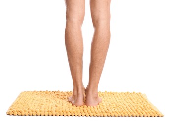 Man standing on soft yellow bath mat against white background, closeup