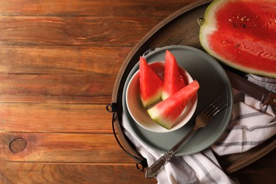 Photo of Sliced fresh juicy watermelon on wooden table, top view. Space for text
