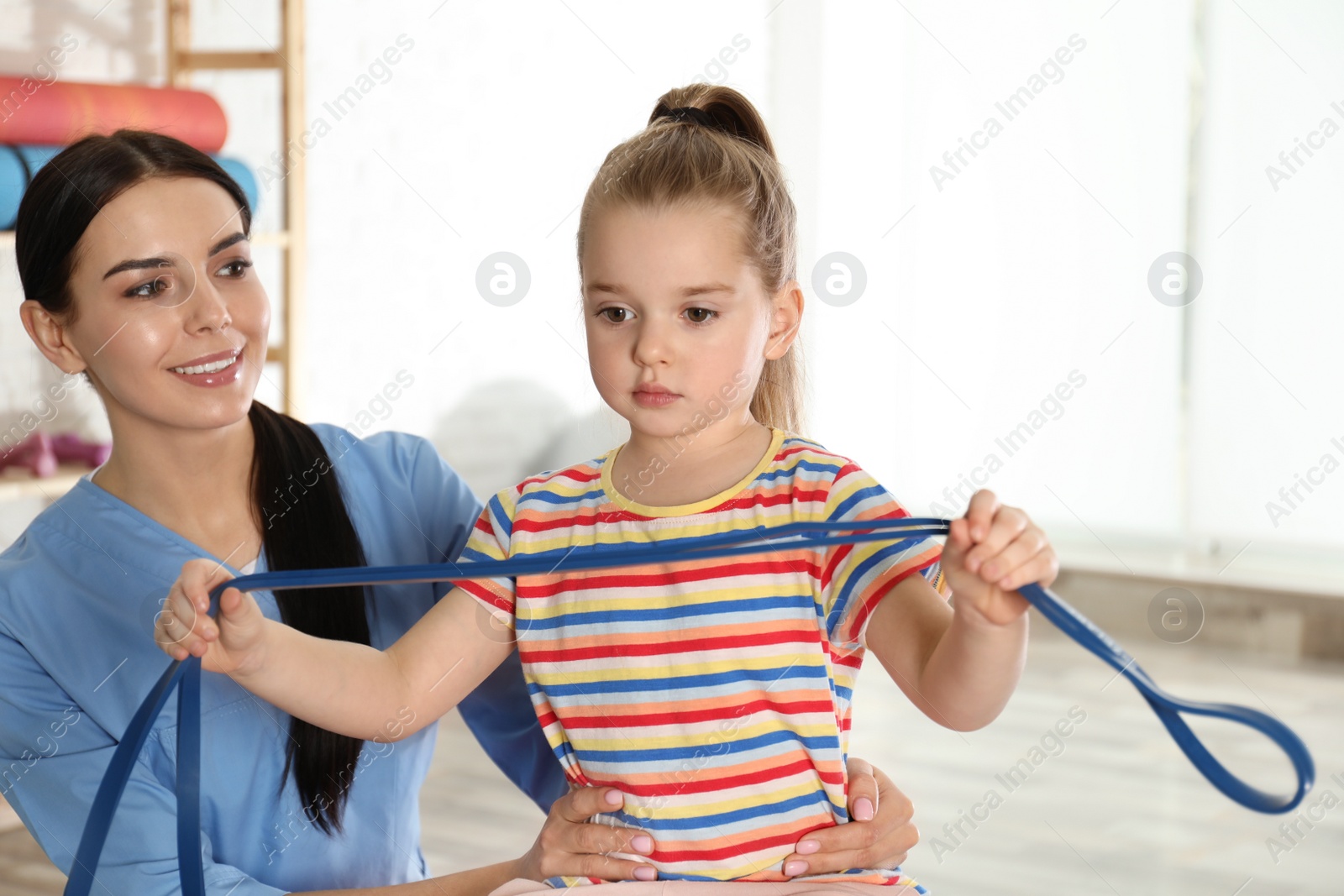 Photo of Orthopedist working with little girl in hospital gym