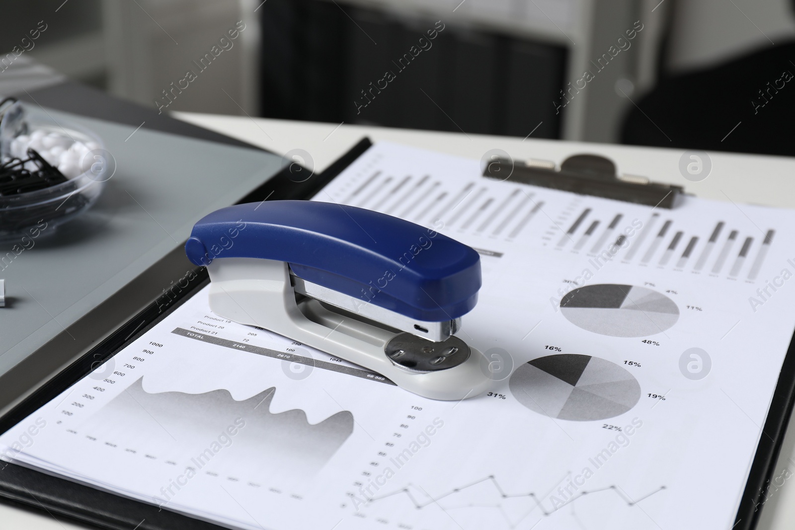 Photo of Stapler and document on white table indoors