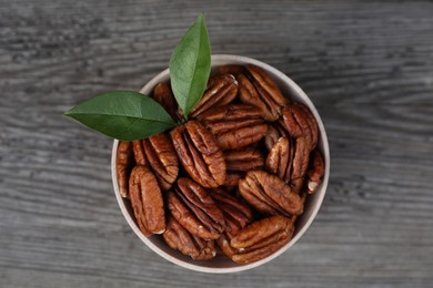 Photo of Tasty pecan nuts on grey wooden table, top view