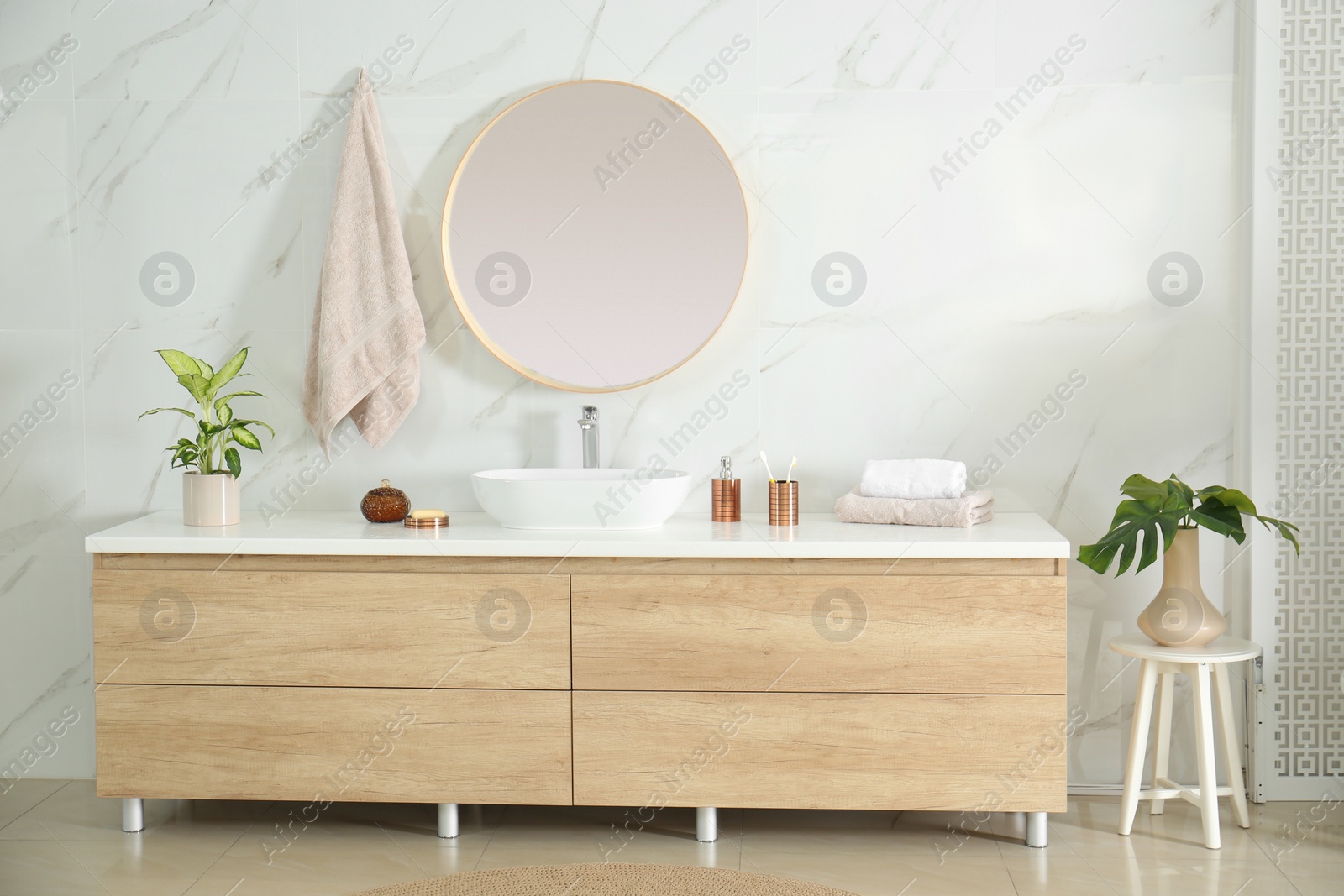 Photo of Round mirror over vessel sink in stylish bathroom interior