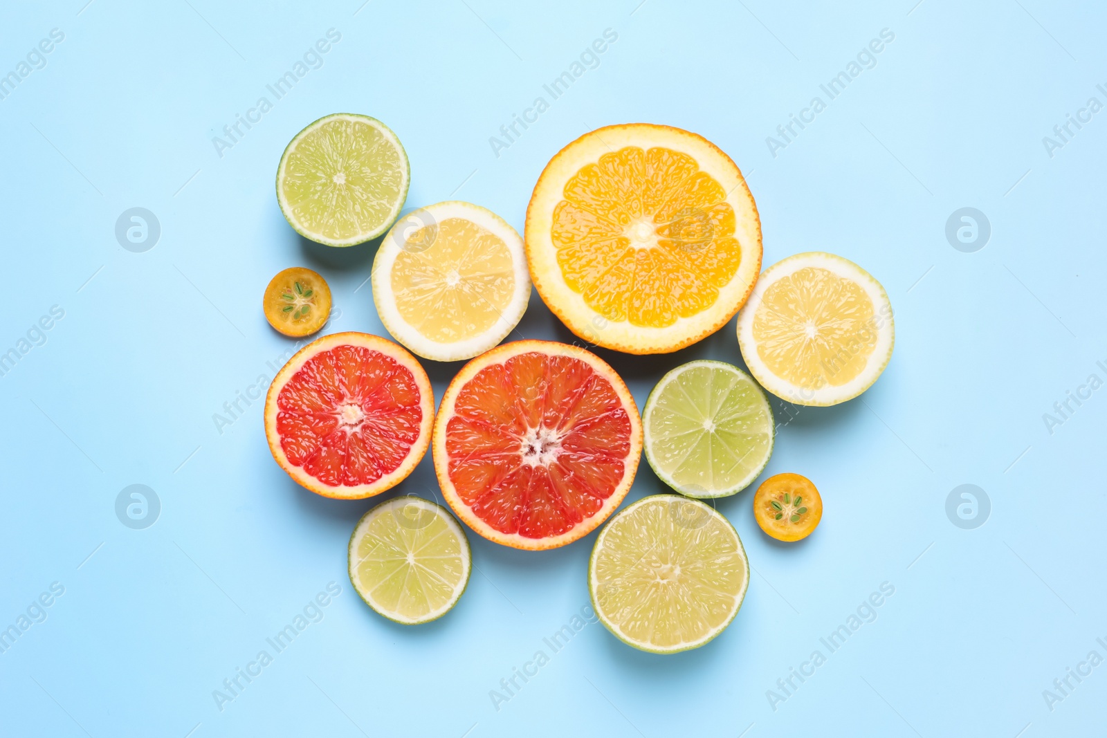 Photo of Fresh juicy citrus fruits on light blue background, flat lay