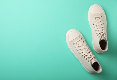 Photo of Pair of stylish sneakers on color background, top view