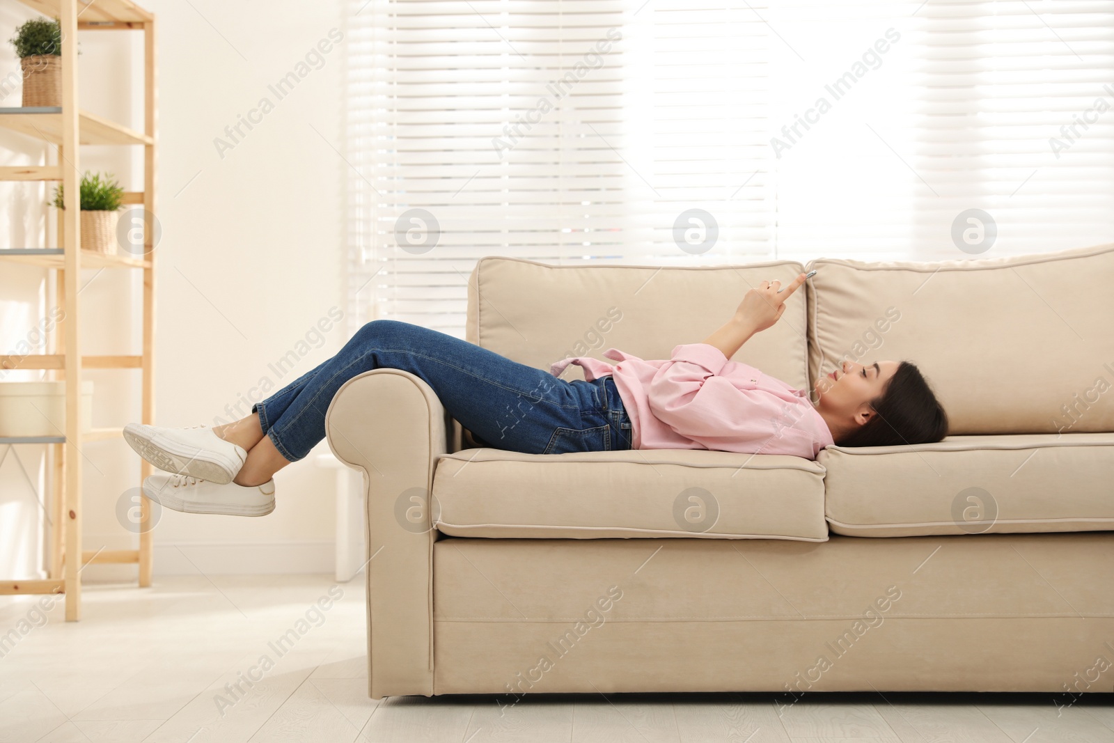 Photo of Young woman addicted to smartphone at home