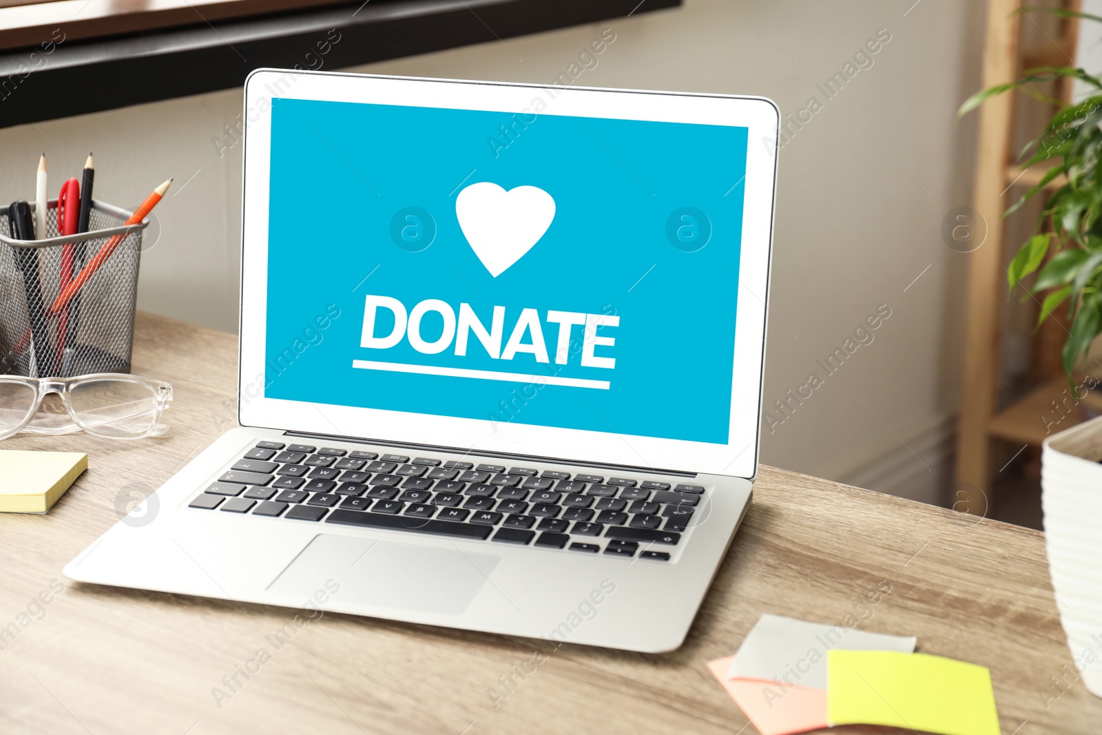 Image of Laptop with text DONATE on wooden table indoors