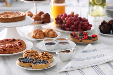 Photo of Variety of snacks on white marble table in buffet style